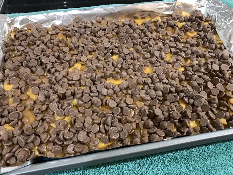 gluten-free chocolate chips scattered on the hot caramel covered crackers