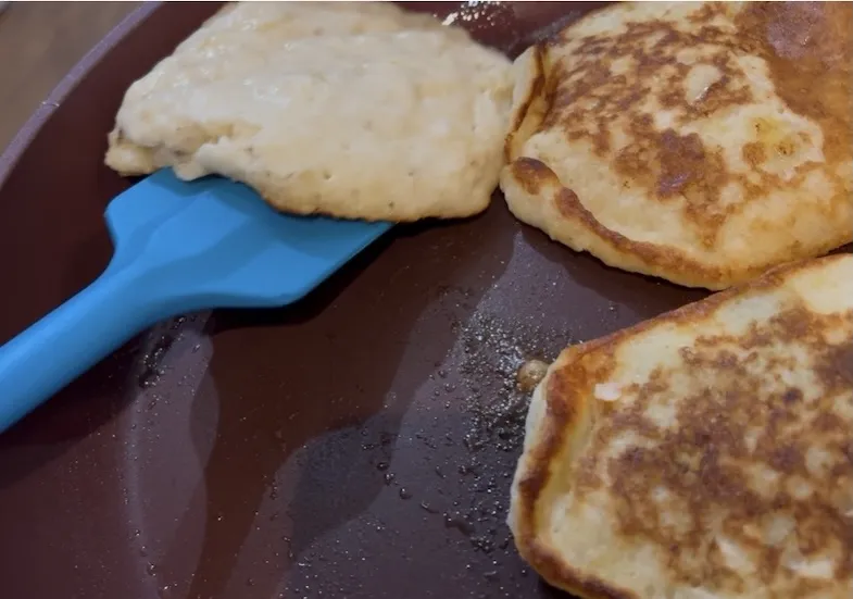 banana pancakes cooking in pan
