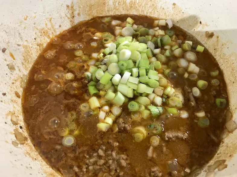 adding cut green onions